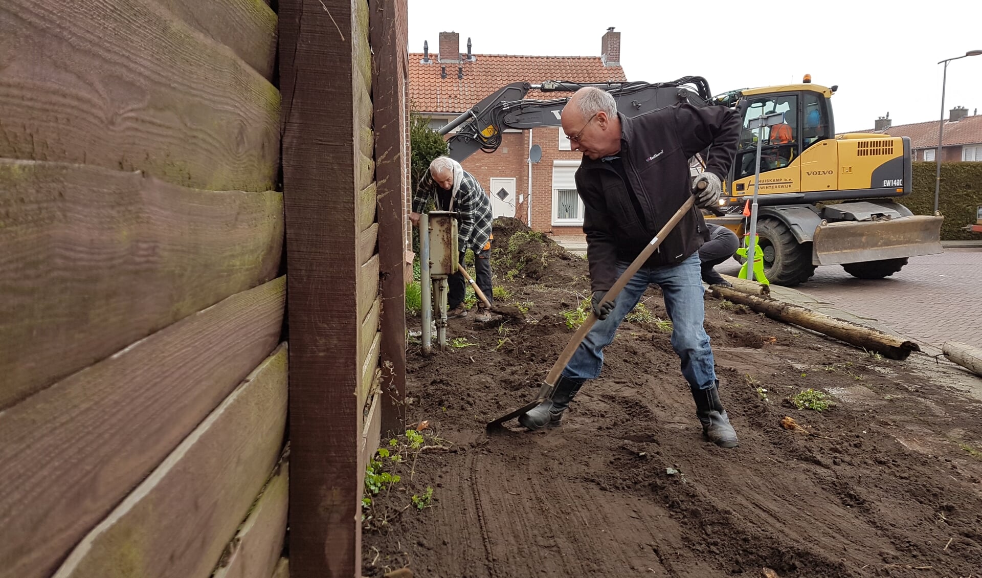 Vrijwilligers van Present en Loonwerkersbedrijf Huiskamp maken een van de tuinen schoon