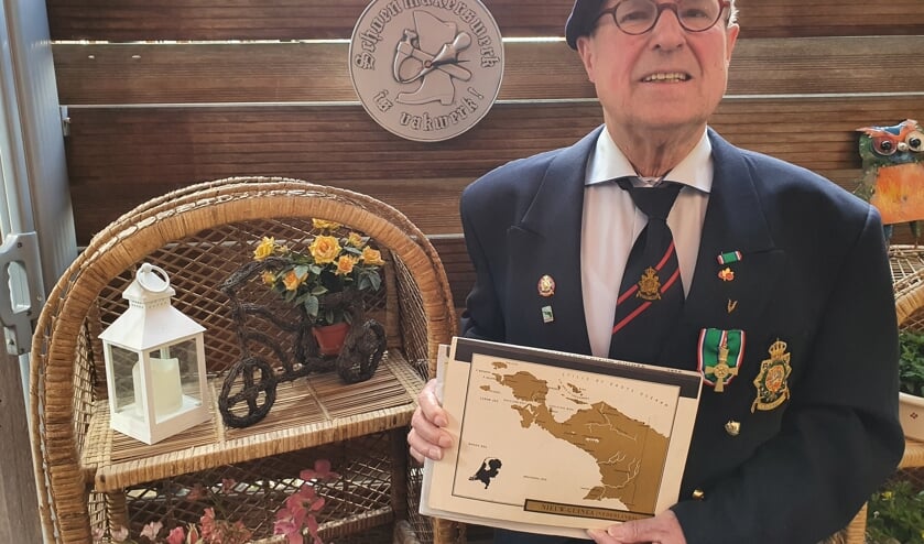 <p>Antoon te Brake trots op zijn decoraties en baret, met de landkaart van voormalig Nederlands Nieuw Guinea. Foto: Henri Walterbos</p>