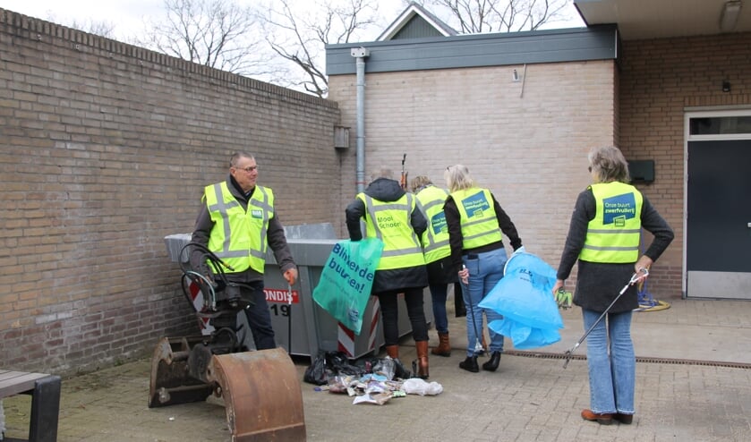 <p>Gerard en een aantal leden van de groep Schoon Oost Gelre bij de afvalcontainer achter het gemeentehuis. Foto: Annekée Cuppers</p>