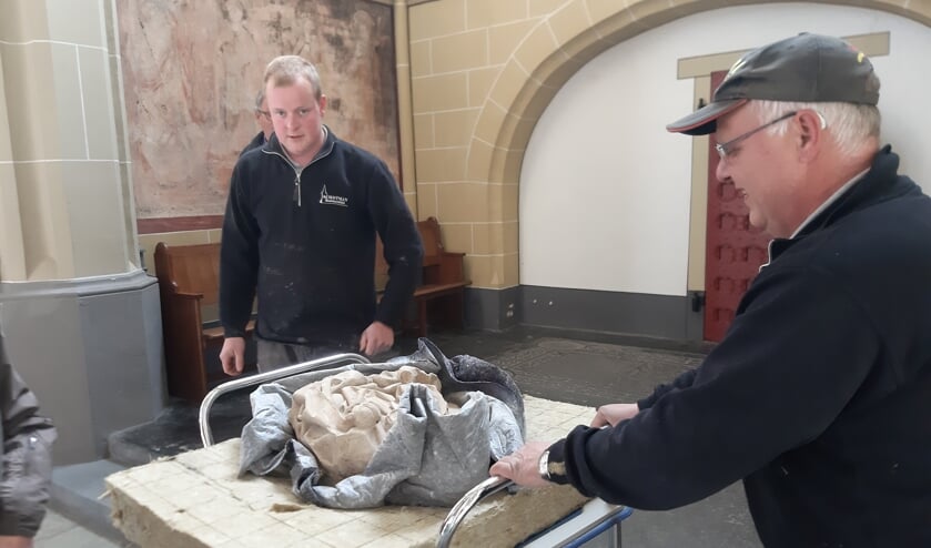 <p>Werner en Peter van Schotman Restauraties vervoeren de sculptuur voorzichtig naar de toonkast. Foto's: Rudi Hofman </p>