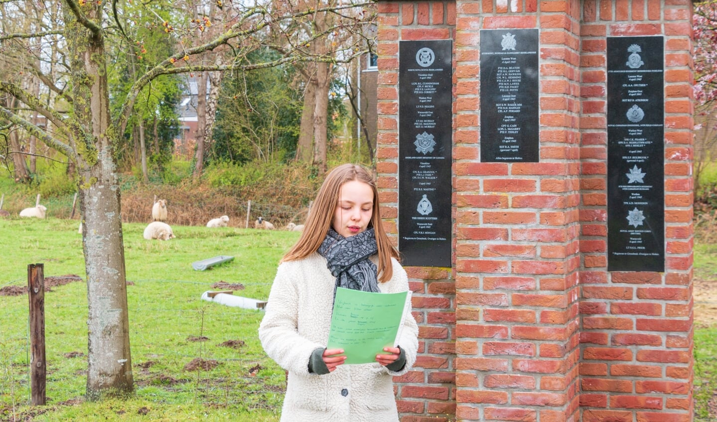 Een van de leerlingen leest haar gedicht voor. 