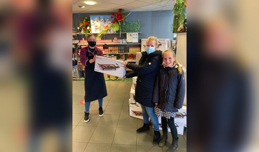 <p>Roos Wiggers van Keurslager Kamperman overhandigt de bakplaat aan een van de winnaars: Istry Tangelder. Foto: PR</p>