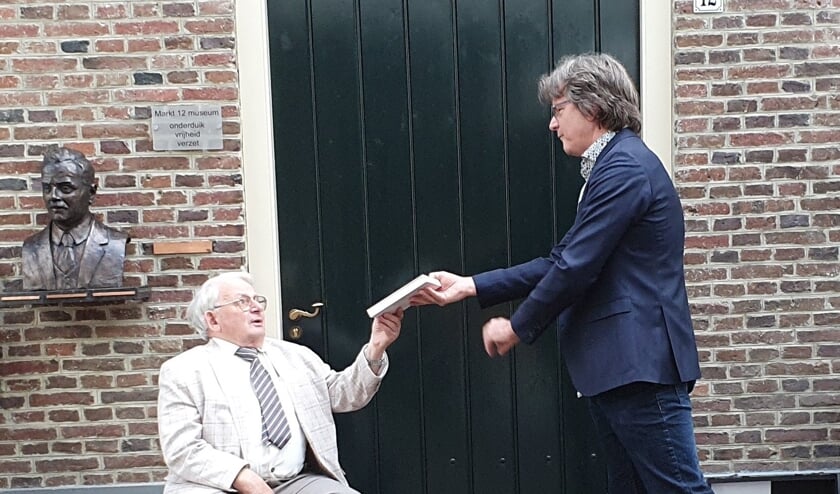 <p>Bernhard Leezer ontvangt het boek van Paul Westmeijer. Foto: PR</p>