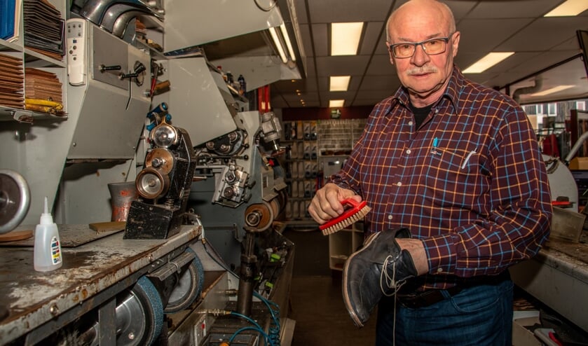 <p>Jan Geurts in zijn schoenmakerij waar hij de schoenen poetst. Foto: Liesbeth Spaansen</p>