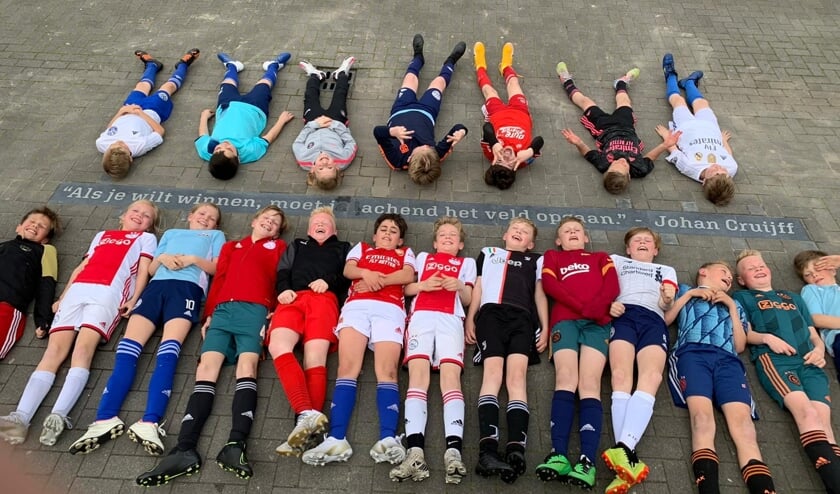 <p>Spelers van JO-11 en JO-12 liggen om de quote heen. Foto: Freddy Brockötter</p>