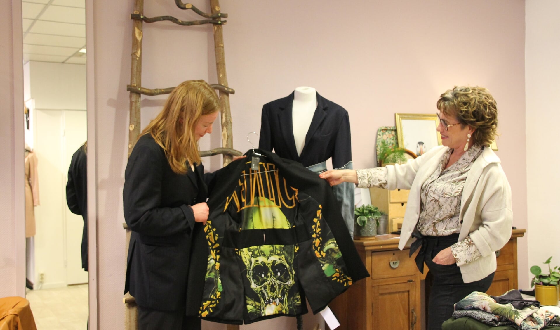 Bo Krabben laat Ingrid Wekking zien hoe ze een vlag van haar favoriete band als voering in een jasje heeft verwerkt. Foto: Annekée Cuppers