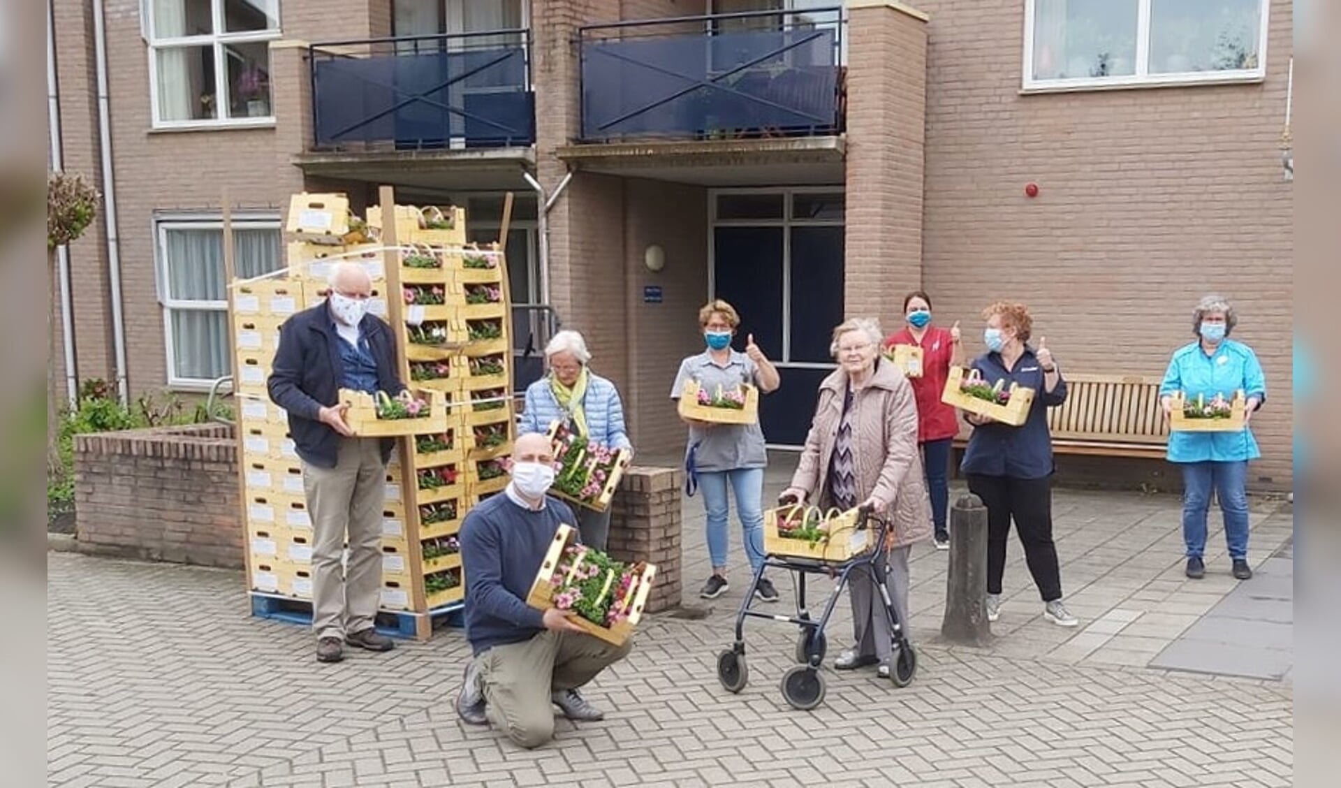 Pieter Stam van Plus (voorgrond) schonk 2400 lentebloeiers aan de bewoners van De Schoven en De Garven. Foto: PR