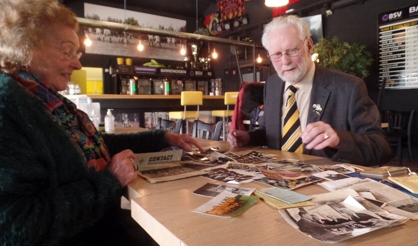 <p>Jan Lindenschot 'snuffelt' samen met Dinie Velhorst tussen alle foto's en krantenartikelen die hij heeft bewaard uit zijn actieve voetbalperiode bij VV Vorden. Foto: Jan Hendriksen </p>