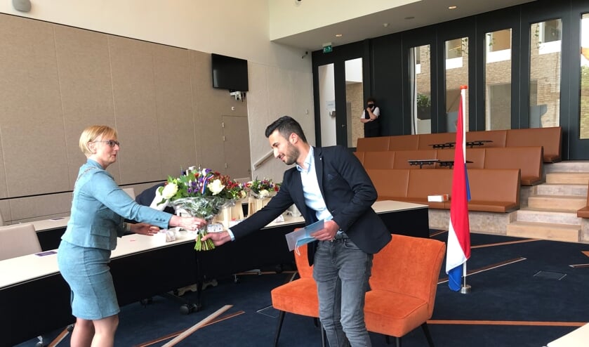 <p>Shervan kreeg uit handen van burgemeester Marianne Besselink zijn papieren voor het Nederlanderschap en bloemen. Foto: PR</p>