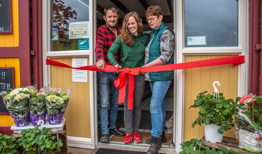 Dick, Iris en Jolanda Garritsen knippen het lint door van de verbouwde winkel. Foto: Liesbeth Spaansen