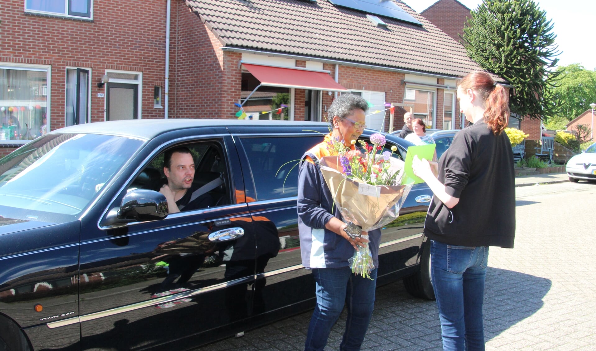 Postbode Hannah krijgt bloemen en cadeaus overhandigd op de Pashegge. Foto: Lydia ter Welle
