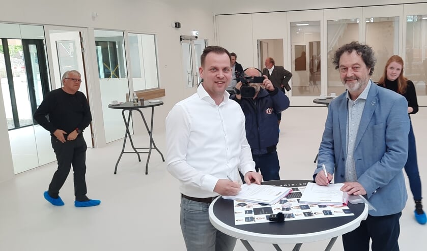 <p>Bart Wopereis van Binx Smartility (links) en Hans Reede van het IEKC ondertekenen de officiële overdrachtspapieren. Foto: Kyra Broshuis</p>