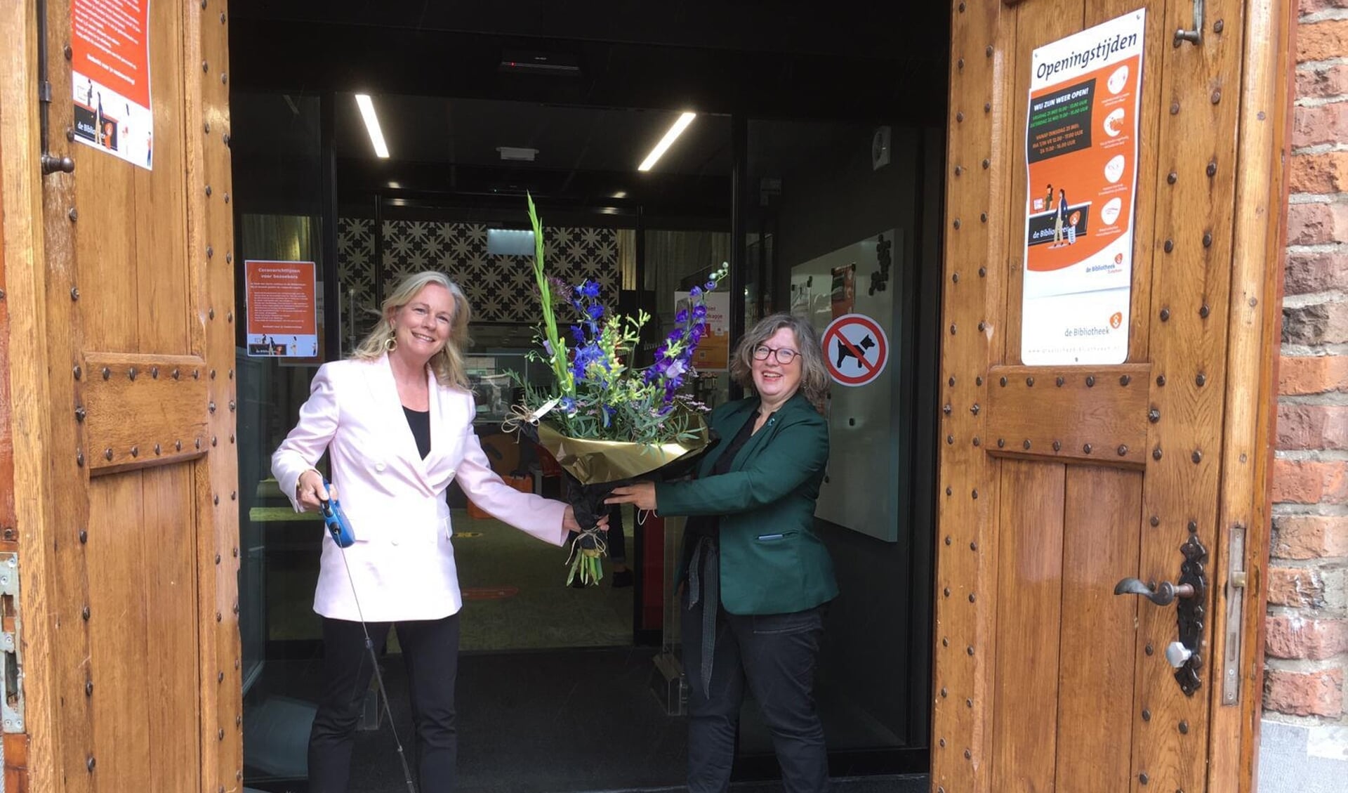 Na opening van de bibliotheek in Zutphen overhandigt burgemeester Vermeulen een bos bloemen aan Barbara Deuss van Graafschap bibliotheken. Foto: PR