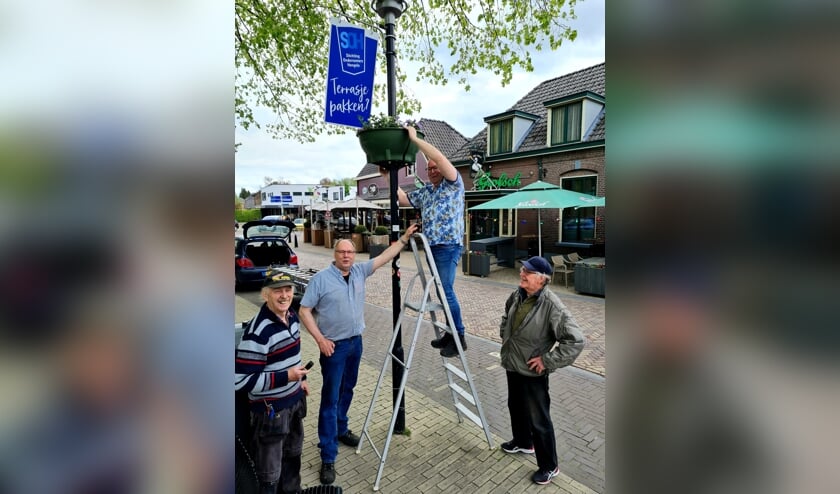 Reint Beunk, Carel Langeler, Rudi Wiendels en Wim Fransen hangen met plezier de bloembakken en promotieborden op. Foto Willy Hermans