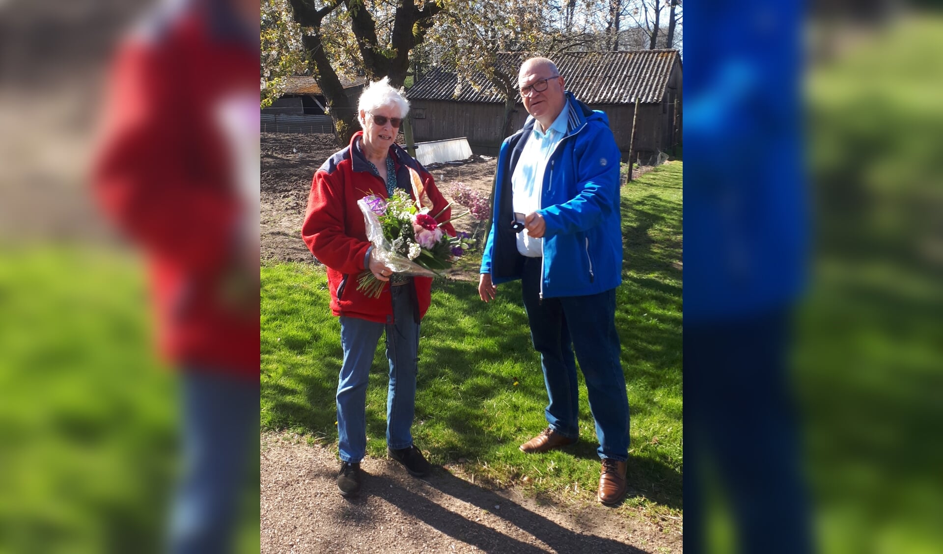 Gerrie Nijenhuis, tien jaar vrijwilligster van de Zonnebloem, ontvangt van voorzitter Henk Hovenga een speld en bloemen. Foto: PR
