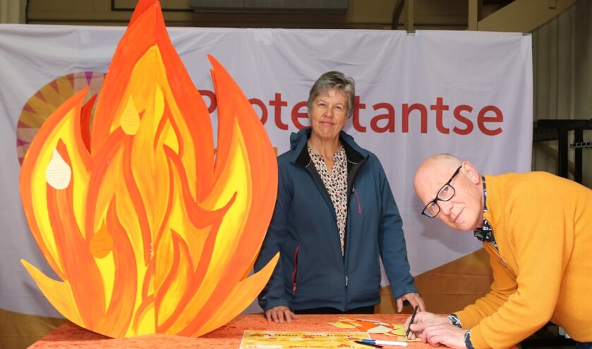 <p>Janny Gerritsen bij de Vlam van Hoop terwijl Sander van Voorst een tekstballon beschrijft. Foto: Arjen Dieperink</p>