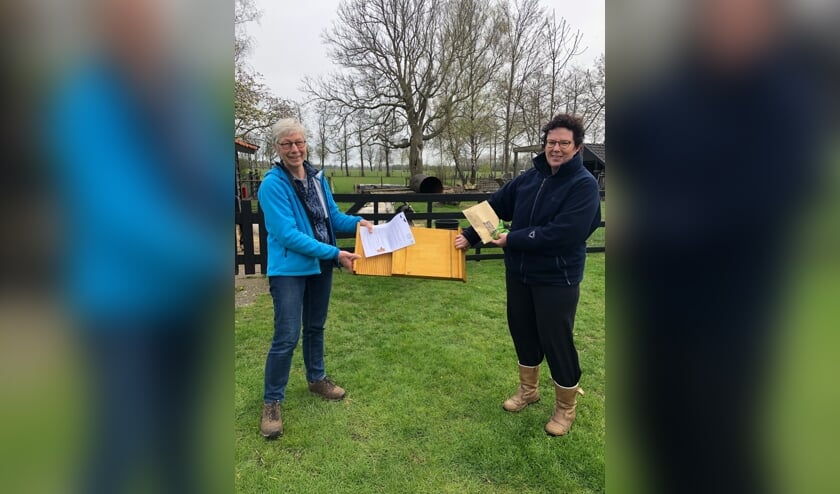 <p>WBH-vrijwilliger Marleen van der Linde (l.) levert bij deelnemer Sandra ter Maat het zaaigoed en de vleermuiskast af. Foto: Marja Polman</p>
