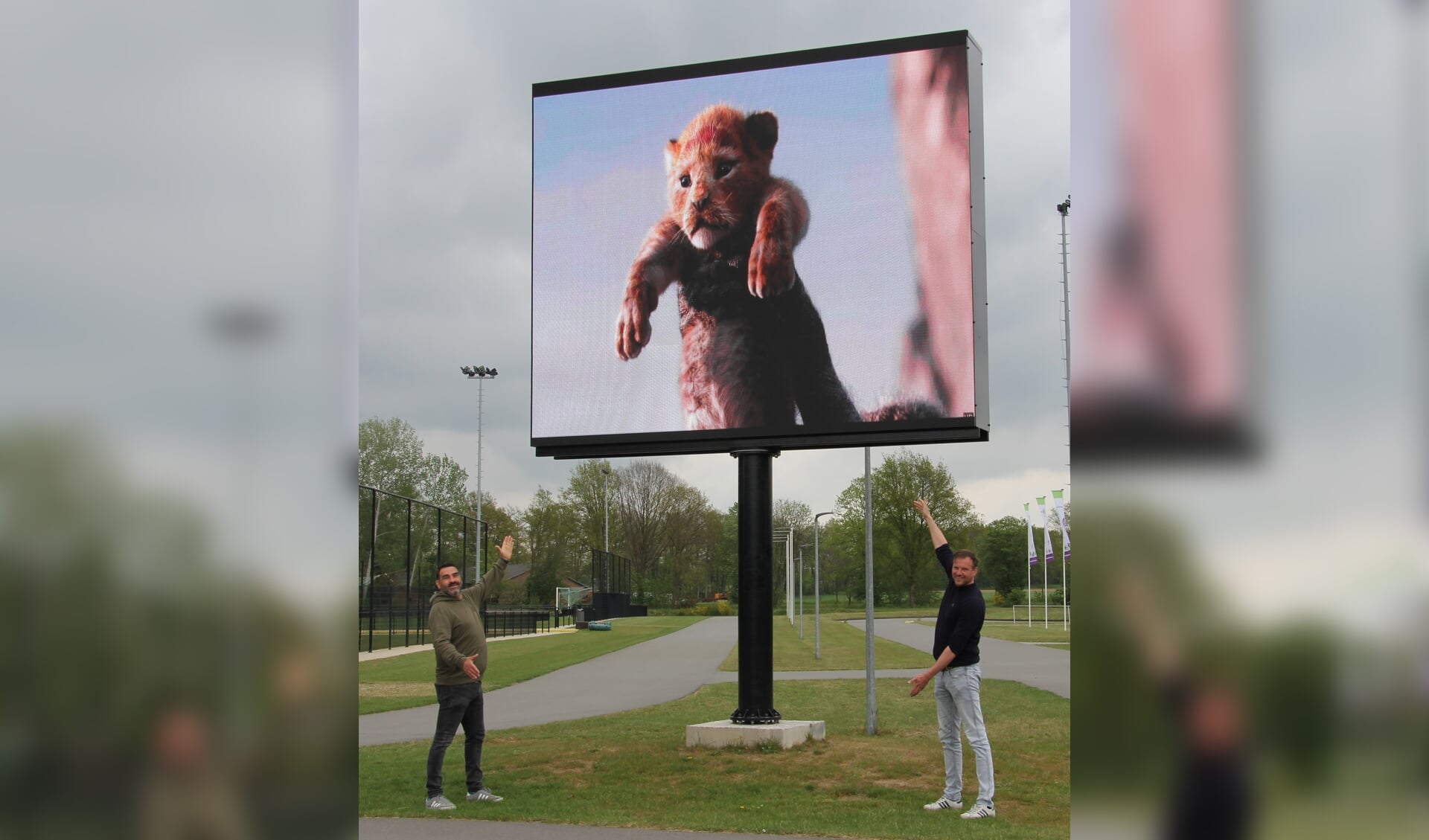Raimond Smit van Sportadvert en Michiel Stronks van Figulus welzijn tonen een preview van The Lion King op het grote LED scherm op Sportpark Zuid. Foto: PR Sportpark Zuid