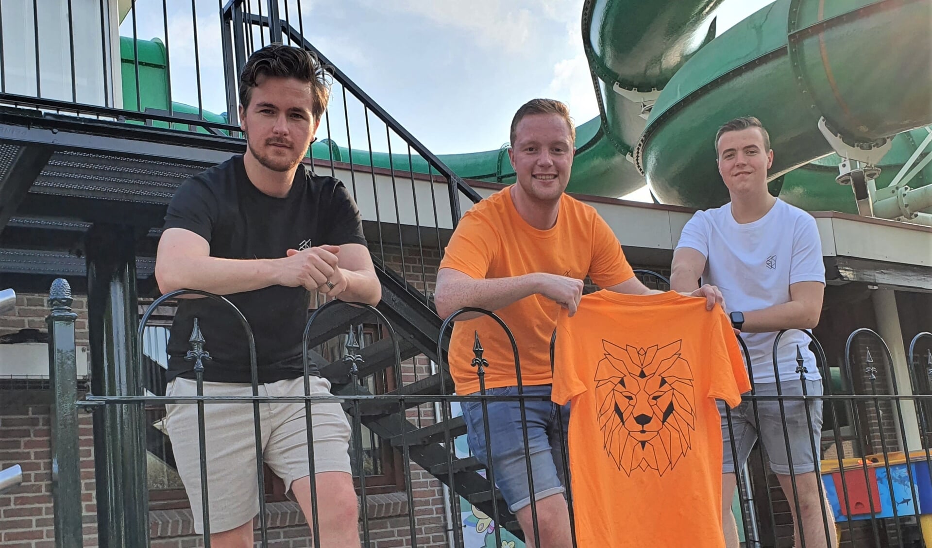 Nick Jansen, Jerle de Jonge en Tim Bomers (vlnr) gekleed in de zelf ontworpen t-shirts. Poserend voor de glijbaan op Marveld Recreatie waar het bedrijfje ontstond. Foto: Henri Walterbos