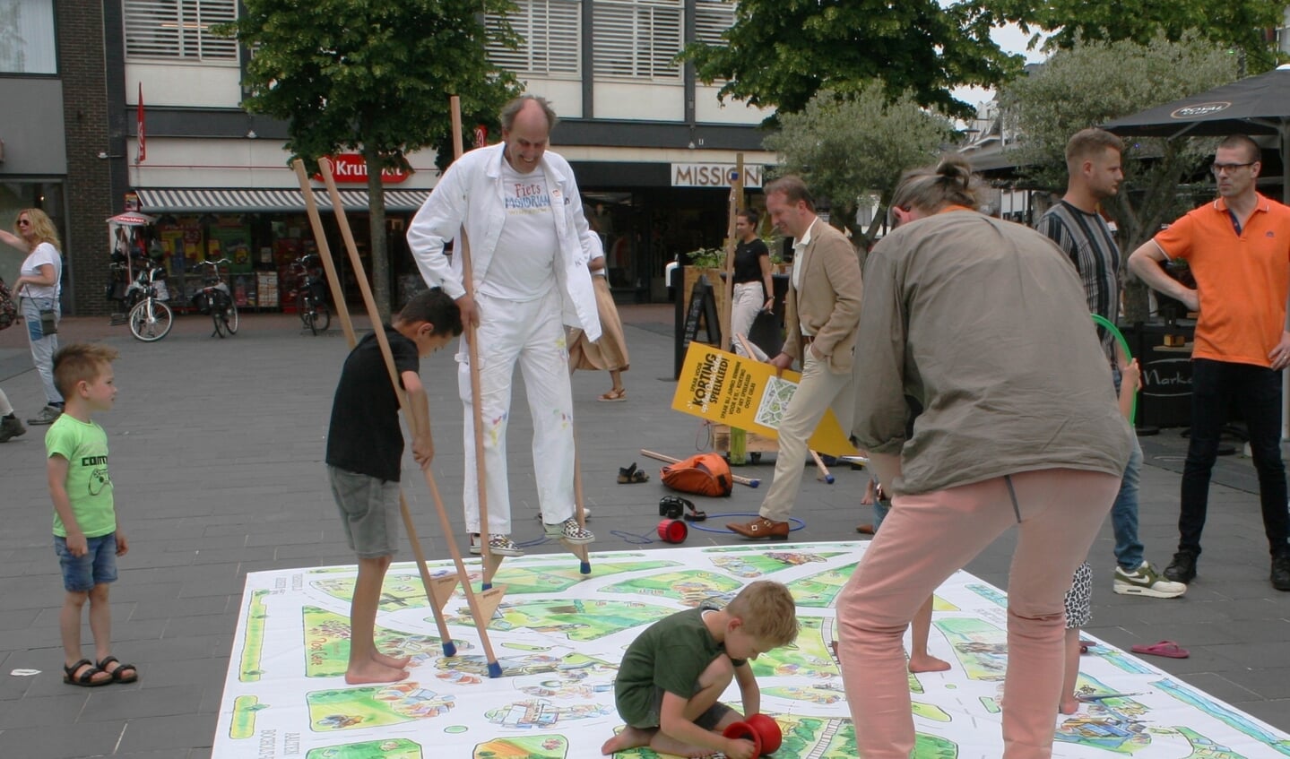 Kunstenaar Vic Hulshof (in het wit) op de stelten over het speelkleed. Foto: Dinès Quist