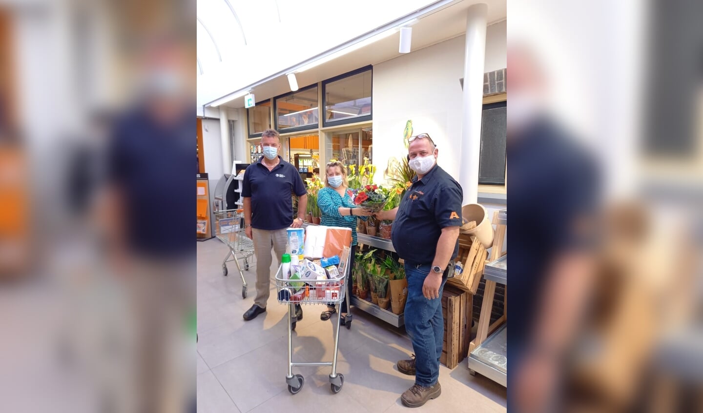 Erik en Loes Jansen uit Drempt wonnen de minuut winkelen. Harold Aalderink reikte na afloop bloemen uit. Foto: Coop Steenderen