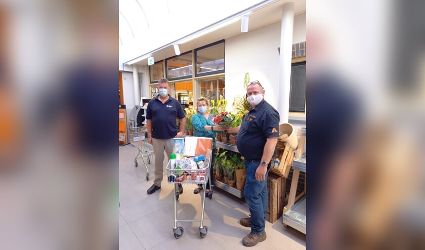 Erik en Loes Jansen uit Drempt wonnen de minuut winkelen. Harold Aalderink reikte na afloop bloemen uit. Foto: Coop Steenderen