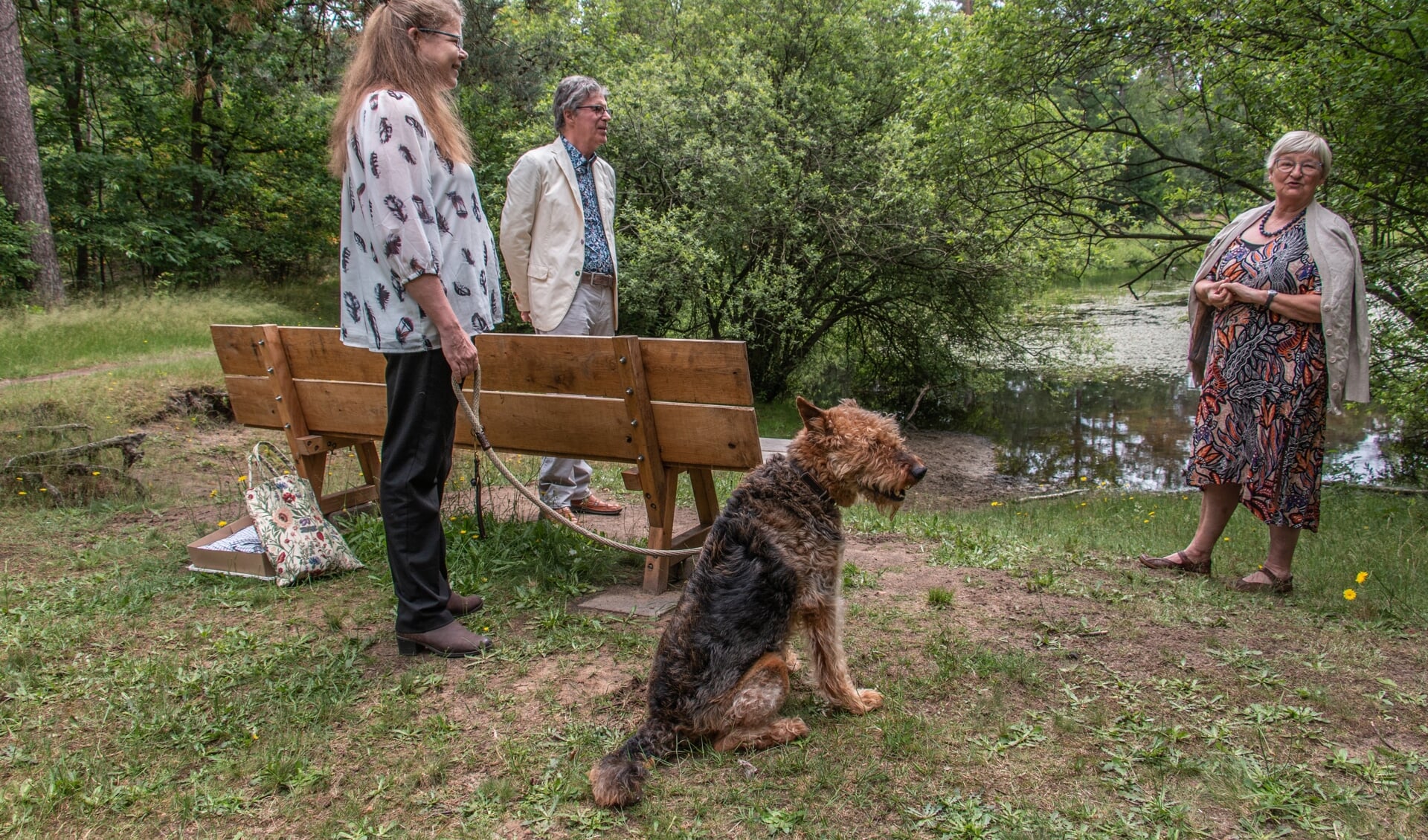 Dankwoorden van Hélène de Fremery (links met hond Amber) voor Peet en Mart Hopmans die een nieuwe bank schonken voor bij het bosven. Foto: Liesbeth Spaansen