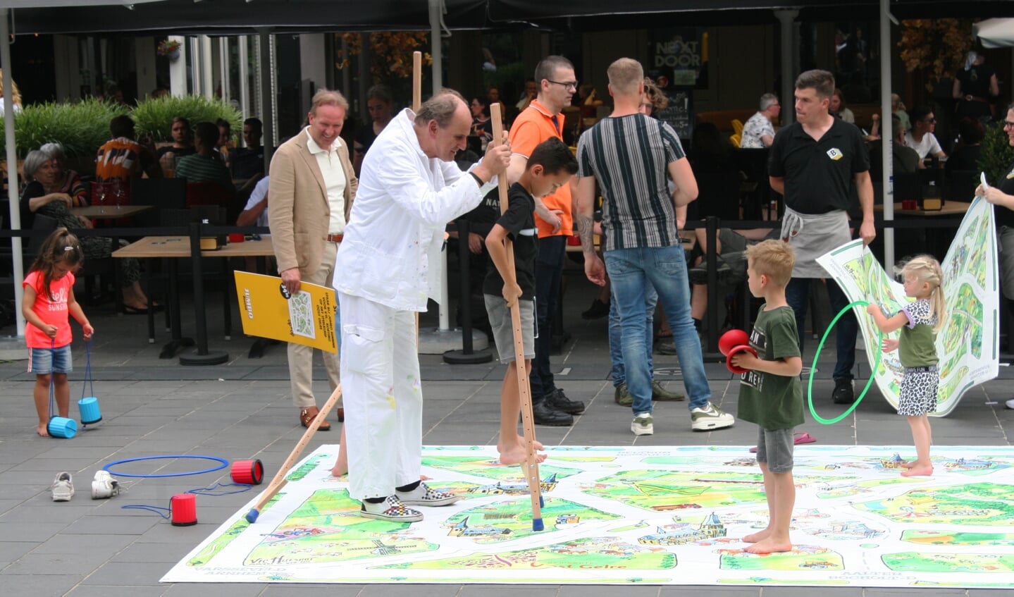Vic Hulsfhof (in het wit) helpt een kindje op de stelten over het speelkleed. Foto: Dinès Quist