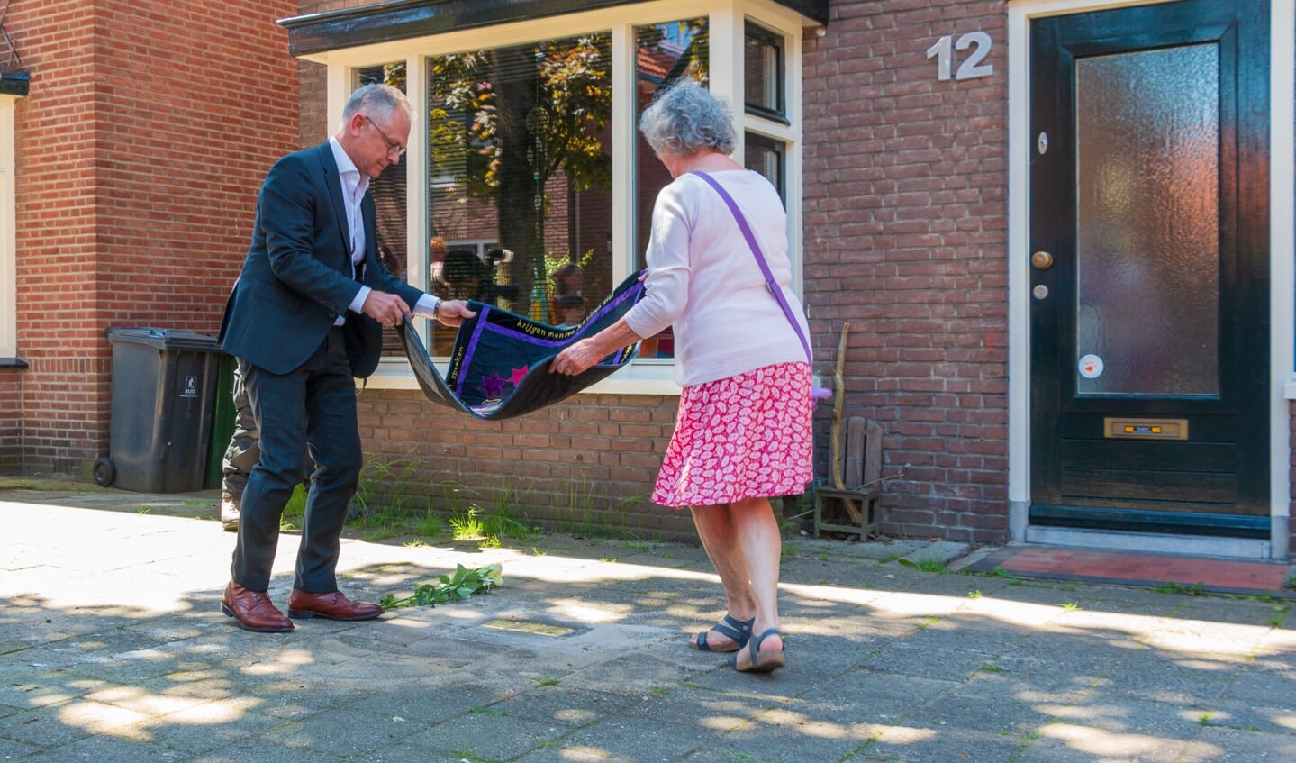 Wim Schipper en Franca Koopman leggen kleed met dichtregels voor de onthulling. Het adres van de familie Heilbronn aan de Rembrandstraat 12. Foto: Henk Derksen  