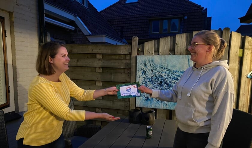 DEO bestuurslid Mieke Kornegoor (links) overhandigt de waardebon aan DEO voetbaldame Kim Veneklaas. Foto: PR DEO
