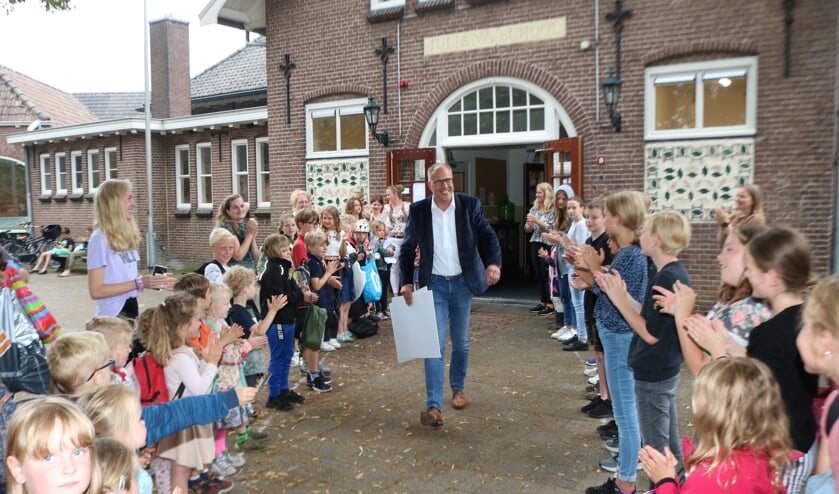 <p>Taco Houkema loopt door de erehaag van de leerlingen. Foto: Arjen Dieperink</p>