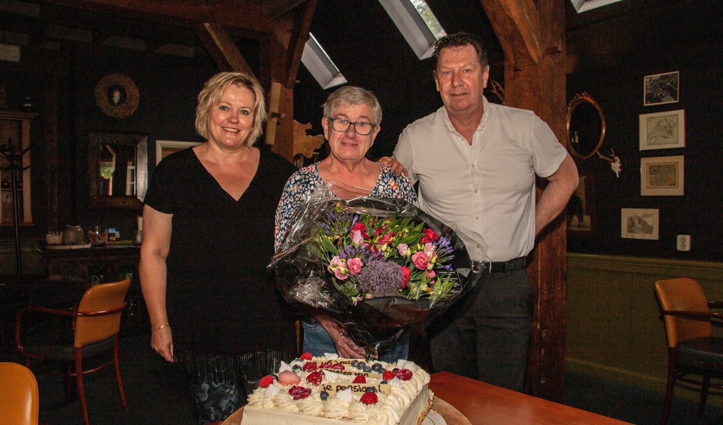 Ans Mulder (m) krijgt van Odeke Brinkhorst en Herman Meutstege alvast een taart en bloemen voor haar pensioen, na 46 jaar Het Wapen van Bronkhorst. Foto: Liesbeth Spaansen