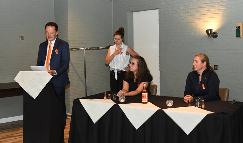 <p>Tijdens de persconferentie presenteert voorzitter Henk Huurnink van het Oranjecomité Vierakker-Wichmond het alternatieve feestprogramma, bijgestaan door doventolk Marieke Tuinman. Achter de tafel zijn bestuursleden Janita Haverkamp en Judith Minderman. Foto: Jantine van de Berg</p>
