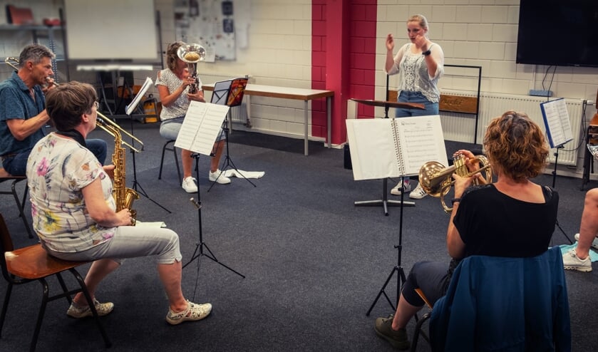 Docent Dorien Jansen Venneboer aan de slag met een aantal muzikanten uit de orkestklas.