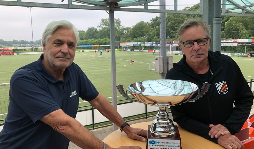 <p>Gerard Greven (l) en Martin van den Burg met de Joop Vreman Wisselbeker die zondag 22 augustus om 16.30 uur wordt uitgereikt aan het team dat zich als opvolger van RSC Anderlecht winnaar weet van het vijfde SallandElectronics U13 Tournament. Foto: Eric Klop</p>