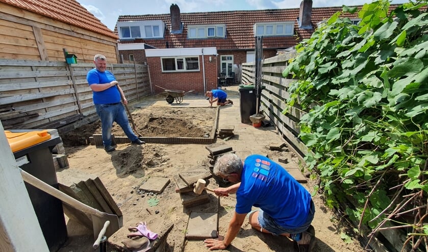 <p>De vrijwilligers zijn druk bezig met het bestraten van de achtertuin. Foto: Present Aalten Dinxperlo</p>