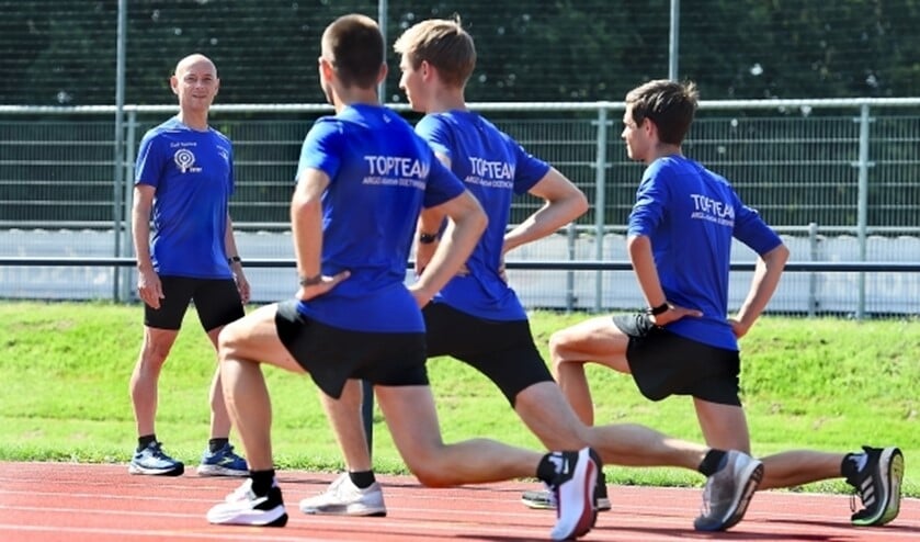 Coach Stefan Scanu (links) kijkt hoe Jordy Kloet, Luuk Nusselder en Ruben Garritsen hun oefeningen doen. 