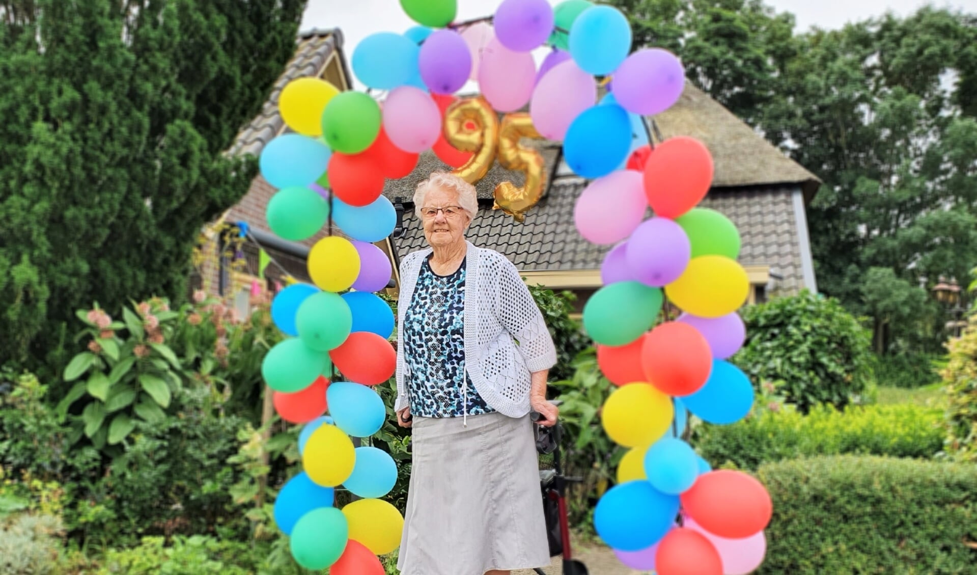 Op de verjaardagstaart van Gerda Gaijkhorst-Kornegoor stonden op maandag 19 juli vijfennegentig kaarsjes. De buurt zette haar in het zonnetje met een ballonenboog. Foto: Alice Rouwhorst