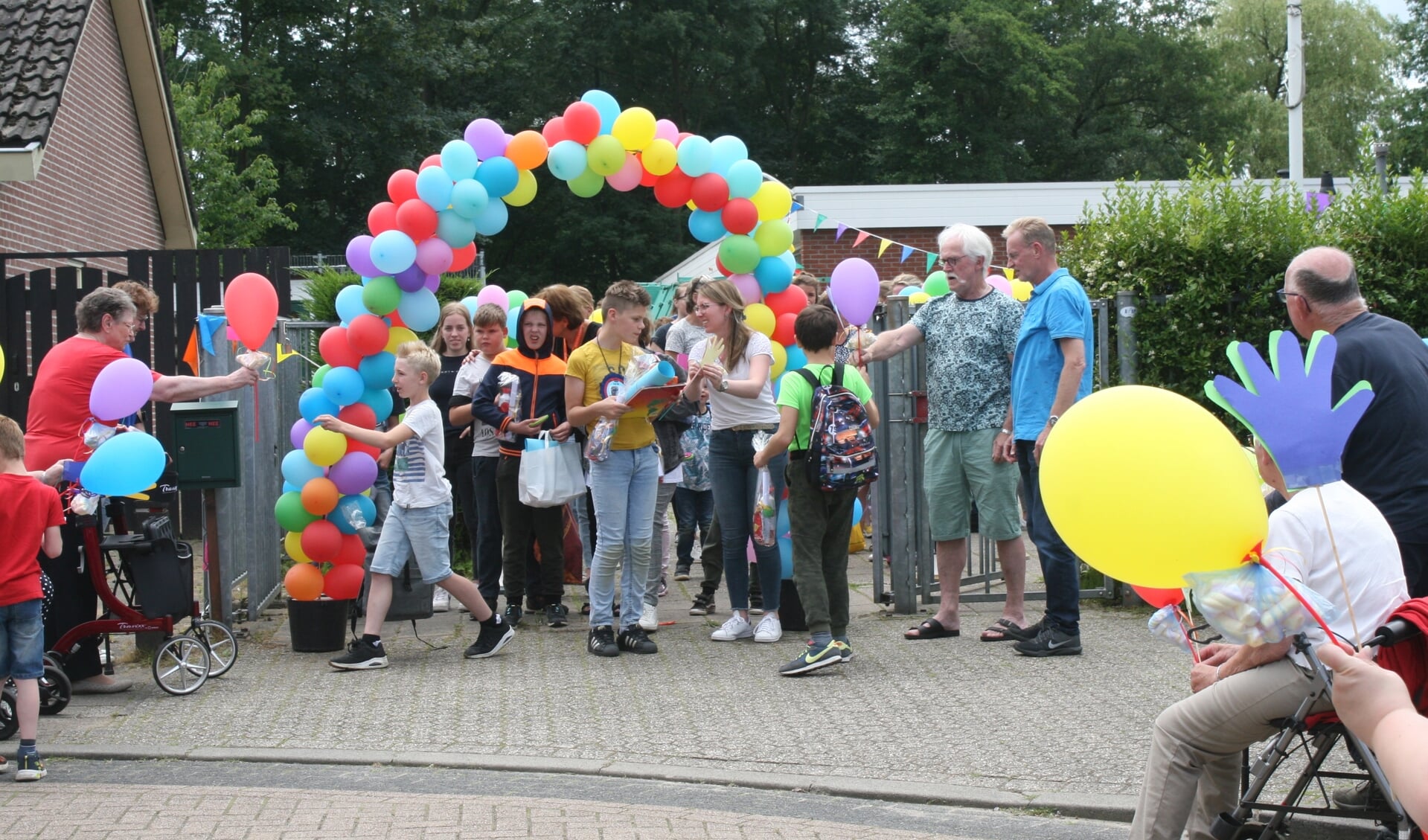 Leerlingen van de Hamalandschool krijgen ballonnen en spekjes van buurtbewoners. Foto: Dinès Quist
