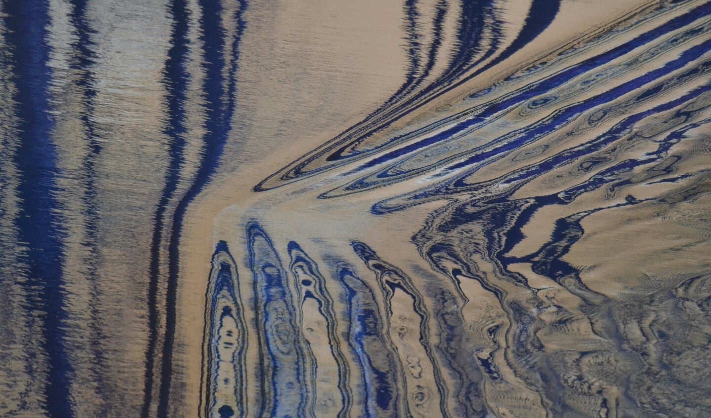 Een abstracte foto van water dat gekeerd wordt door een stuw. Foto Karin Stronks