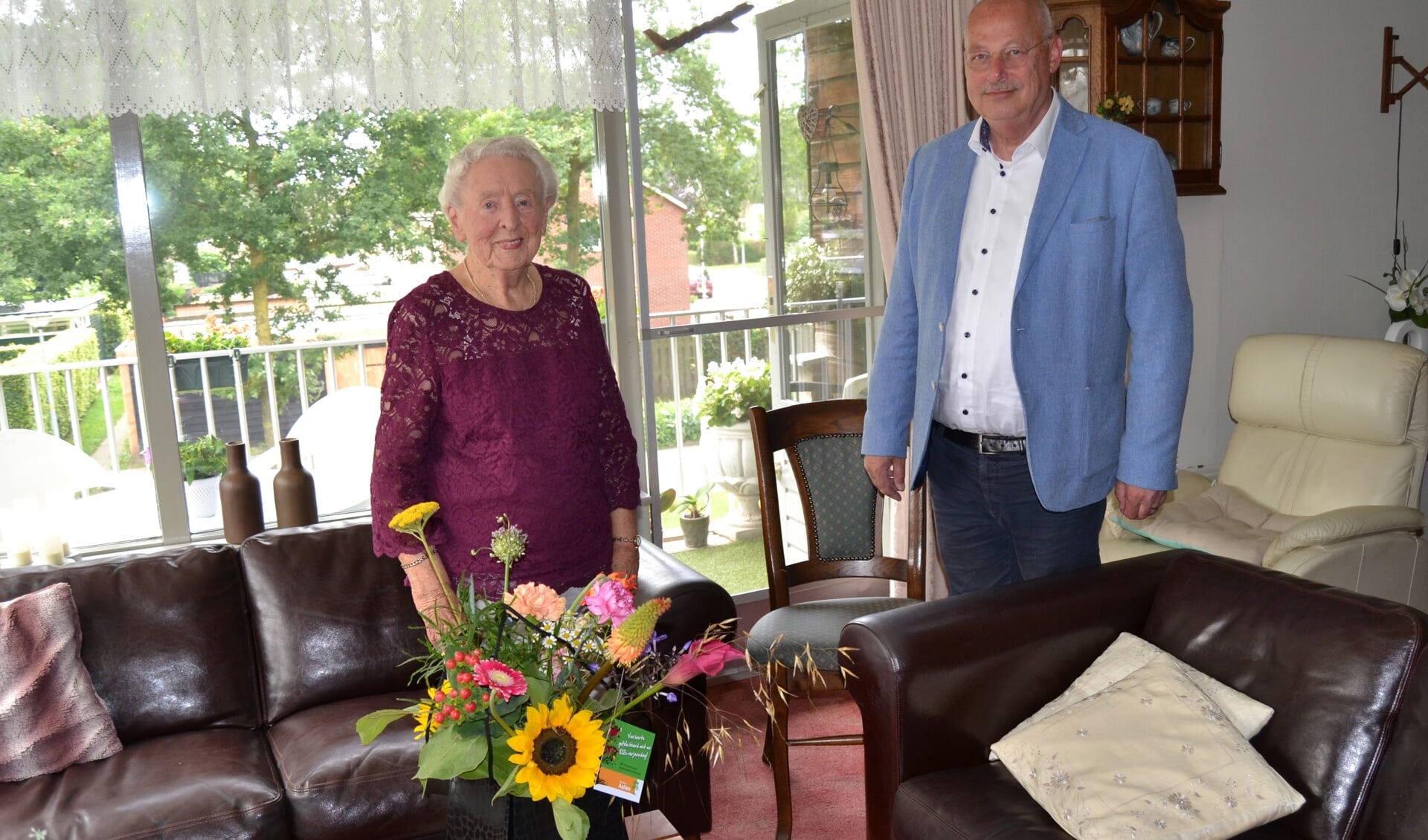 Mevrouw Doortje Rave met wethouder Martin Veldhuizen en het fraaie boeket bloemen. Foto Karin Stronks