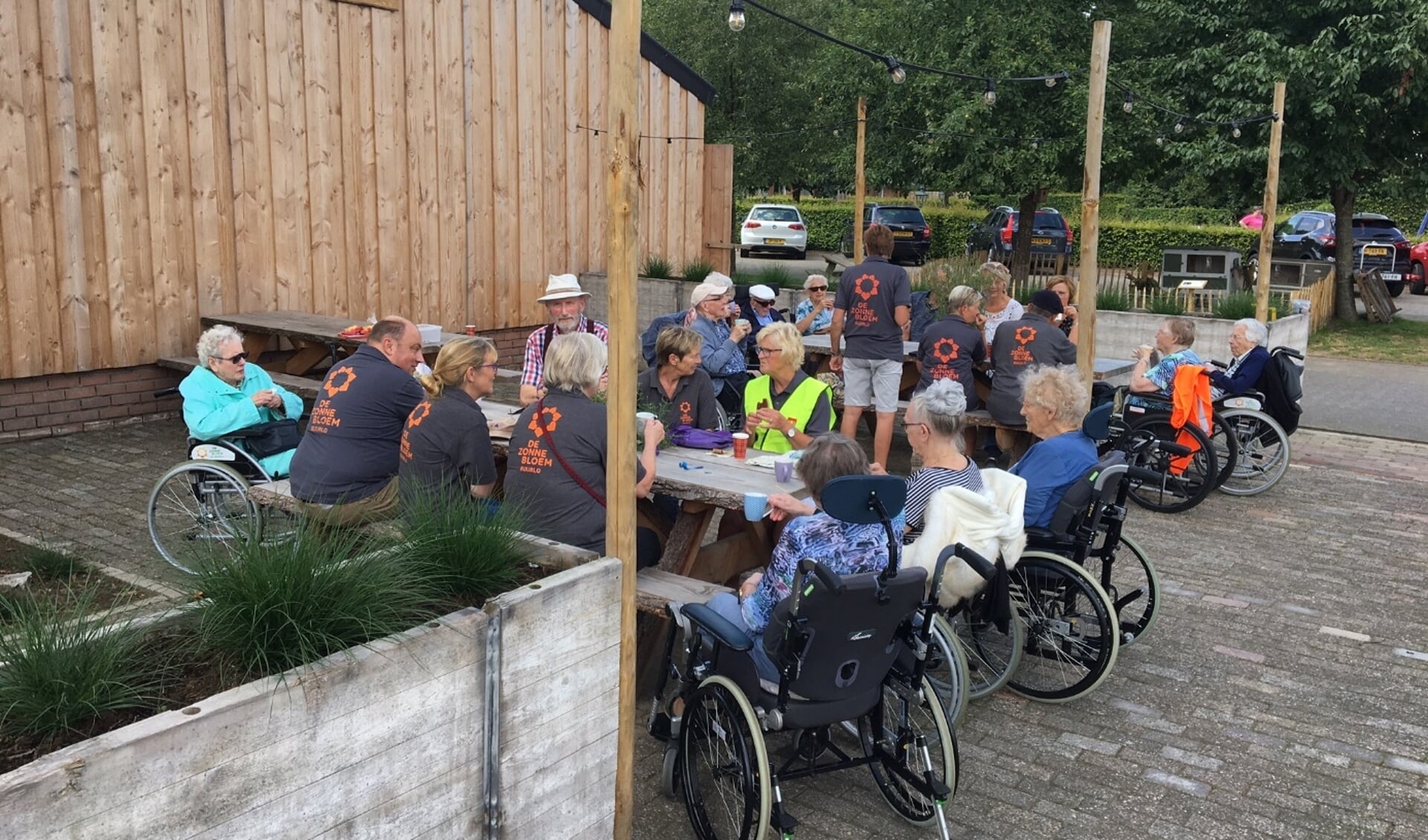 De 24 gasten/vrijwilligers van de Zonnebloem op het mooie terras van camping Schoneveld.  Foto: PR 
