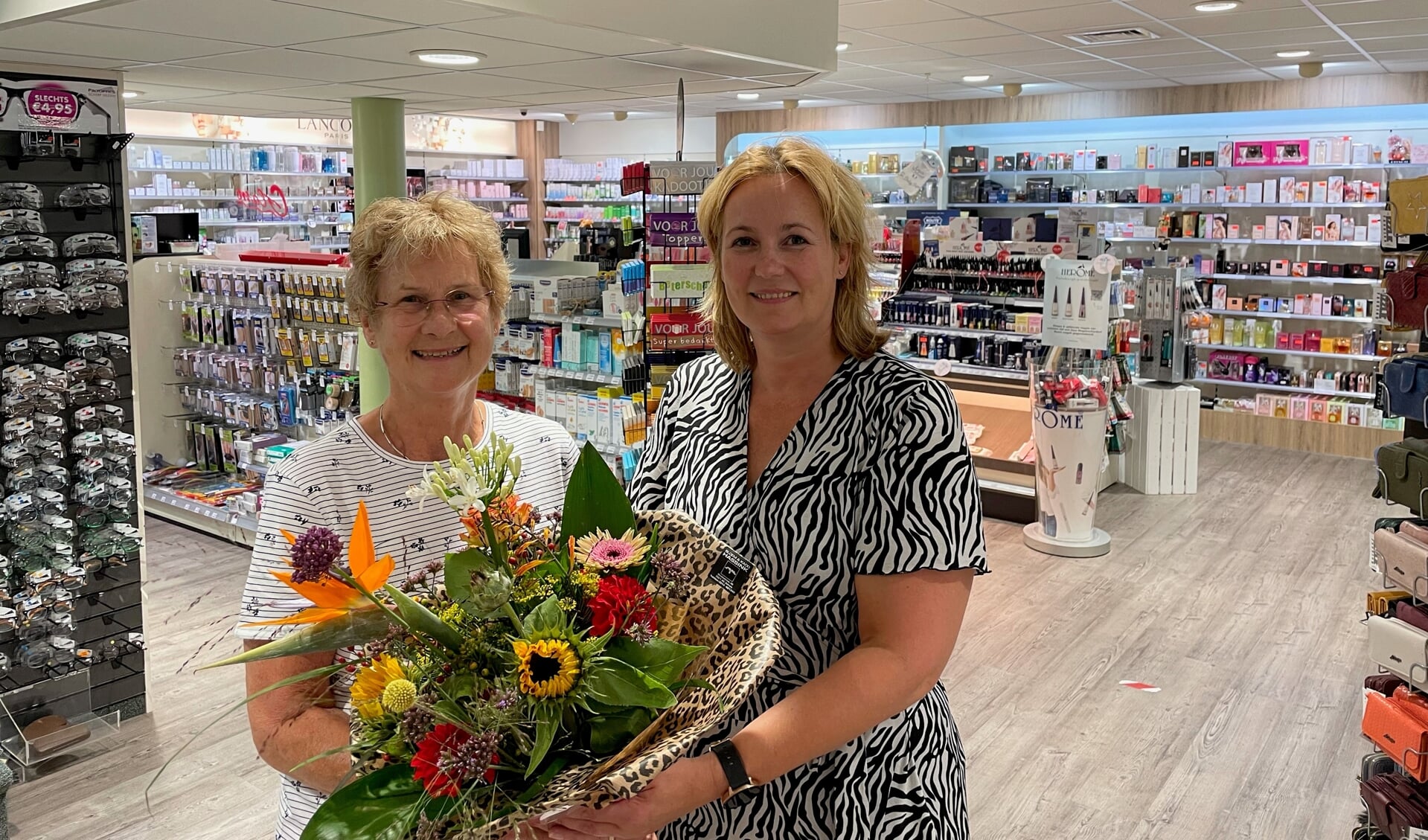 Annemarie Oosterink geeft haar moeder Mini Oosterink bloemen voor 30 jaar werk als bandagist. Foto: PR