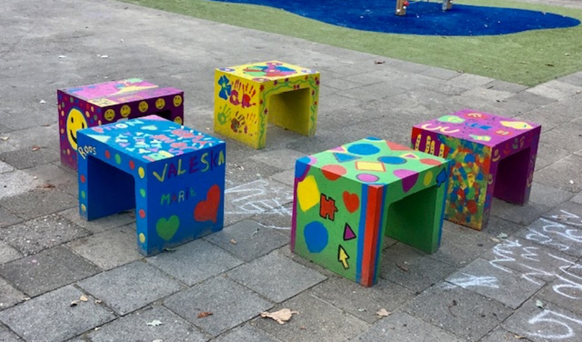 Beschilderde betonnen bankjes op schoolplein De Höve. Foto PR