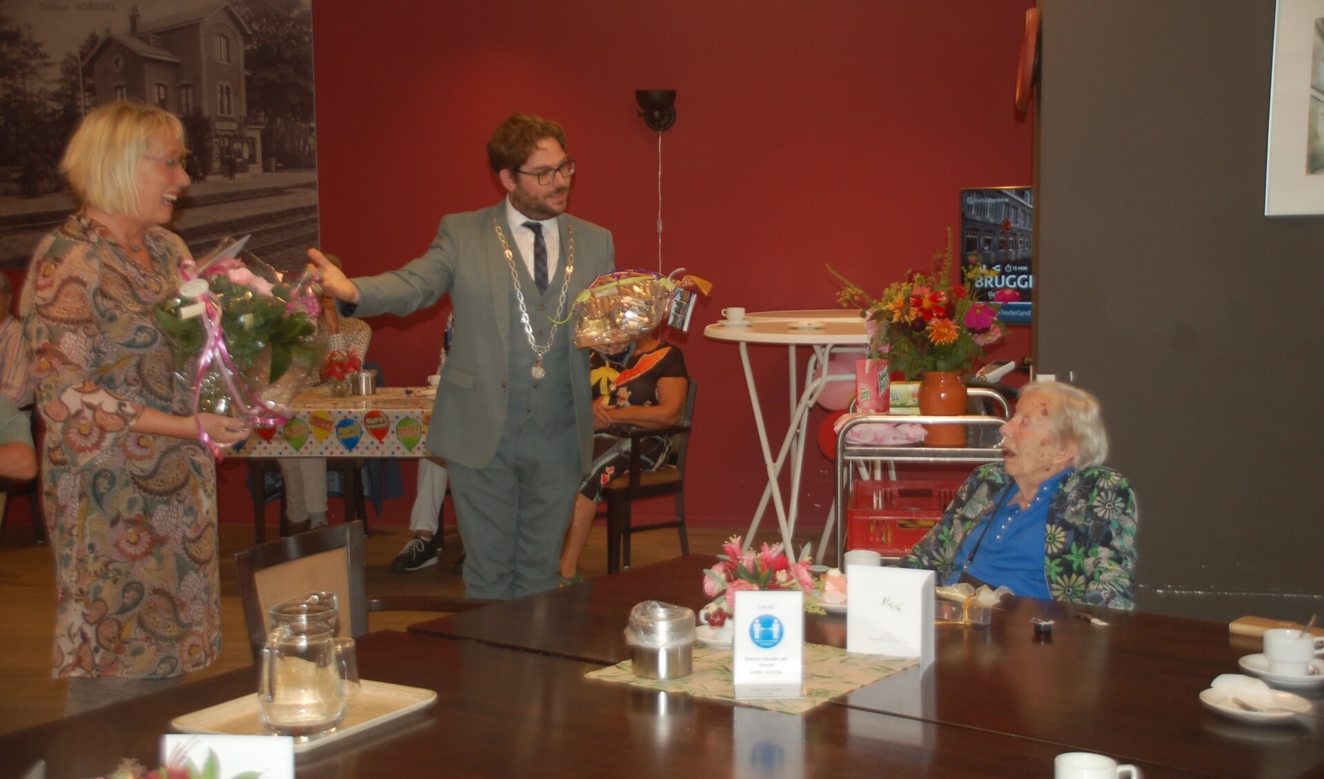 Burgemeesters Loes van der Meijs (Doesburg) en Sebastiaan van ’t Erve (Lochem) spreken de honderdjarige Gerrie toe. Foto: PR