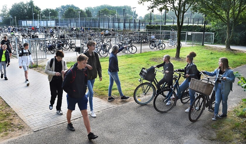 <p>Conciërge Isala Yvonne Mijnen wijst de leerlingen de ingang van de fietsenstalling bij Laudis en Almende College. Foto: Roel Kleinpenning</p>