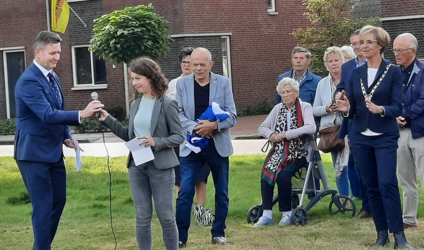 Walter Leemreize van de Stichting 4 en 5 mei Lichtenvoorde overhandigt de microfoon aan Vlinder Kruip. Achter haar staat Jan Geerdinck. Foto: Kyra Broshuis