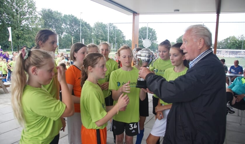 <p>Het winnende meisjesteam Bosmark A krijgen de beker uit handen van Willy te Grotenhuis. Foto: Frank Vinkenvleugel</p>