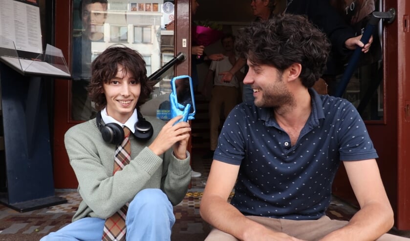 <p>Ainslie Gilewski (links) wint de Glorious Luxorious Award 2021. Naast hem zit Jólan van der Wiel, de ontwerper van de filmprijs. Foto: Sharon Kromotaroeno</p>