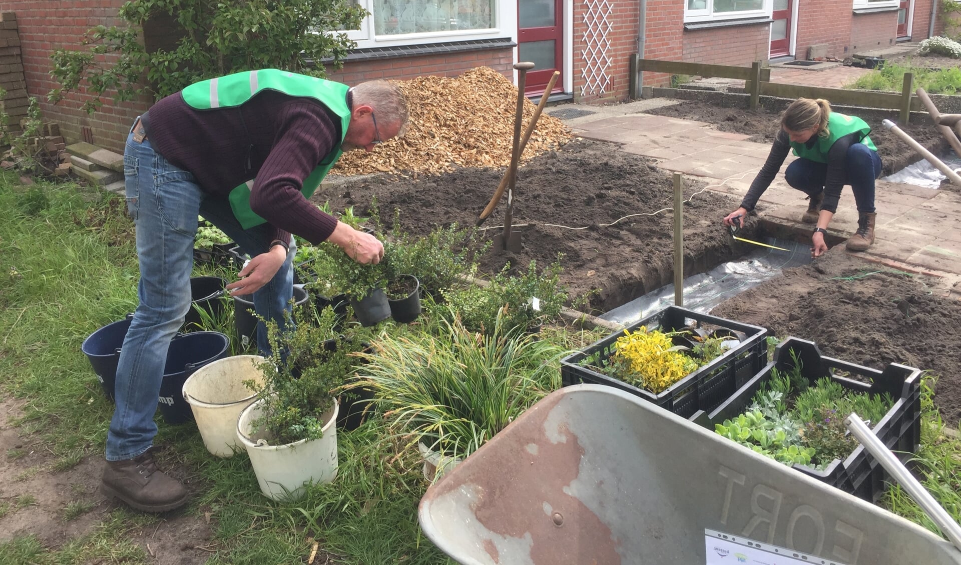 Twee vrijwilligers planten een voortuin duurzaam in tijdens de Sociaal Groen-dag in het voorjaar. Foto: Present Bronckhorst